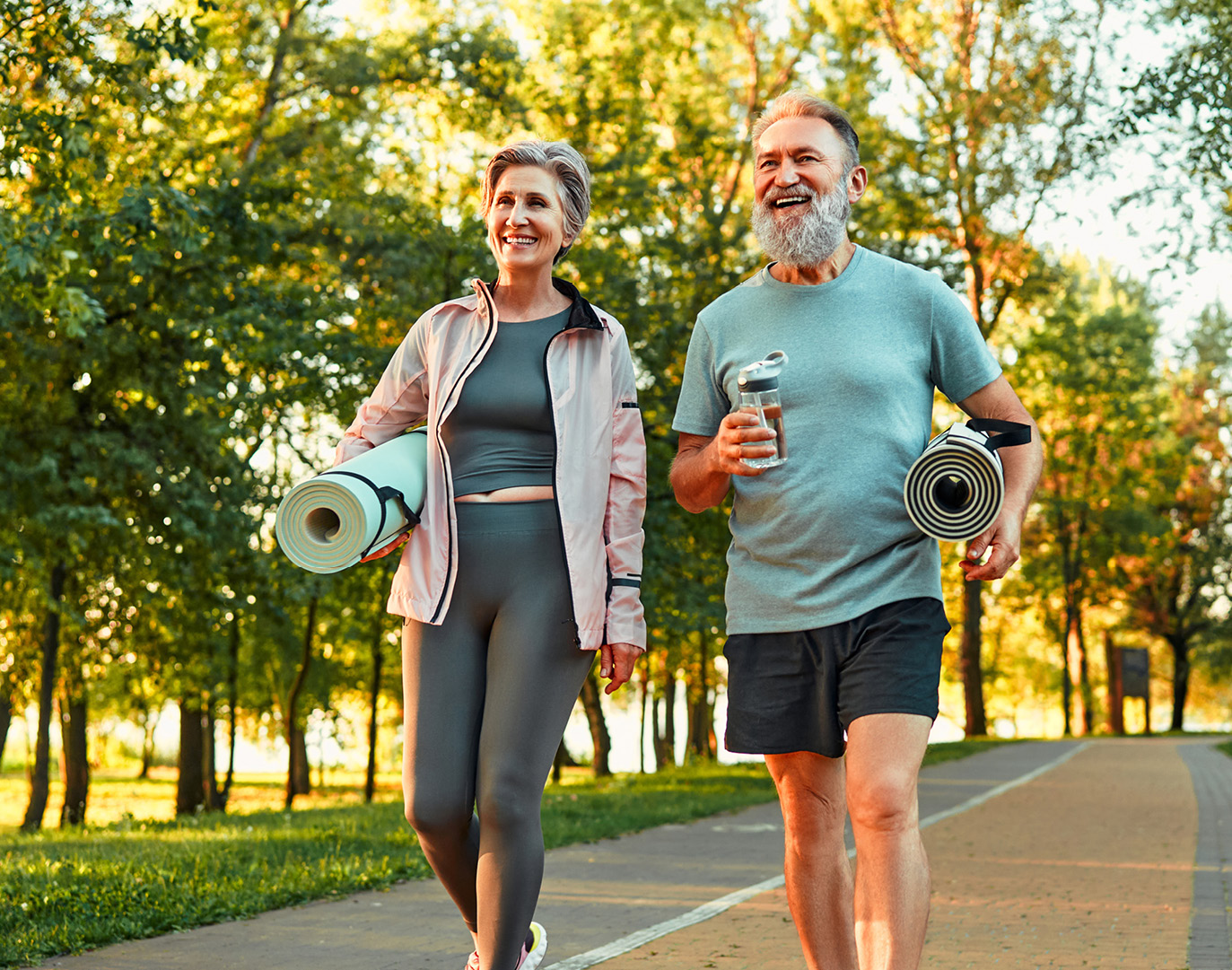 Older adults walking with yoga mats outdoors