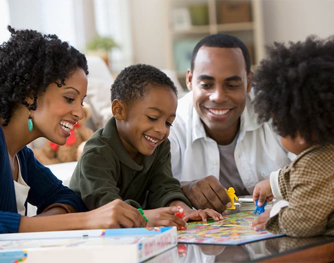 Family playing board game together at table