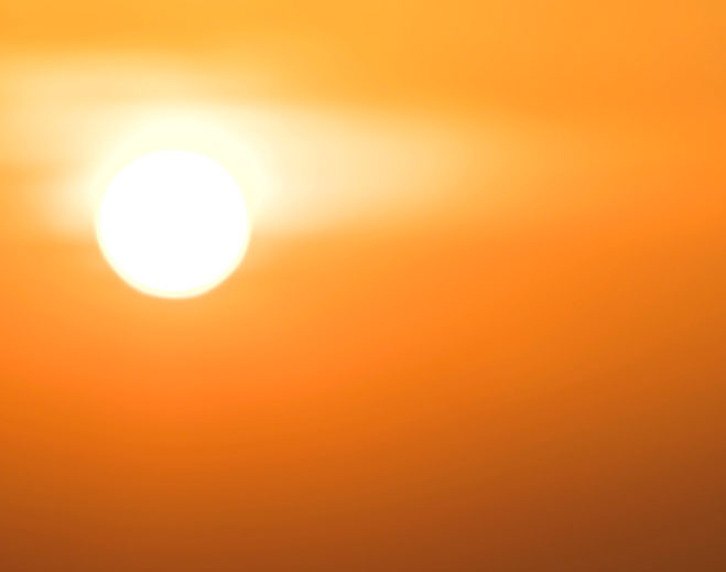 Bright sun in clear orange sky