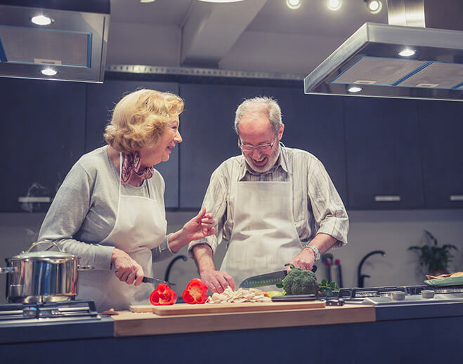 Two adults cooking vegetables together