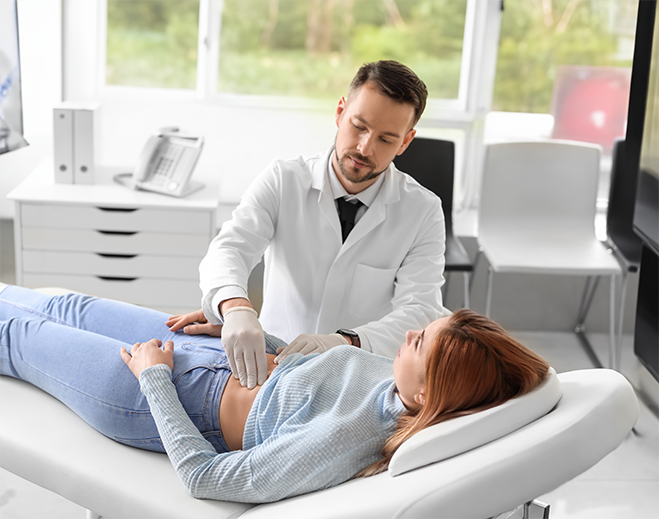 Clinician examining patient abdomen in room