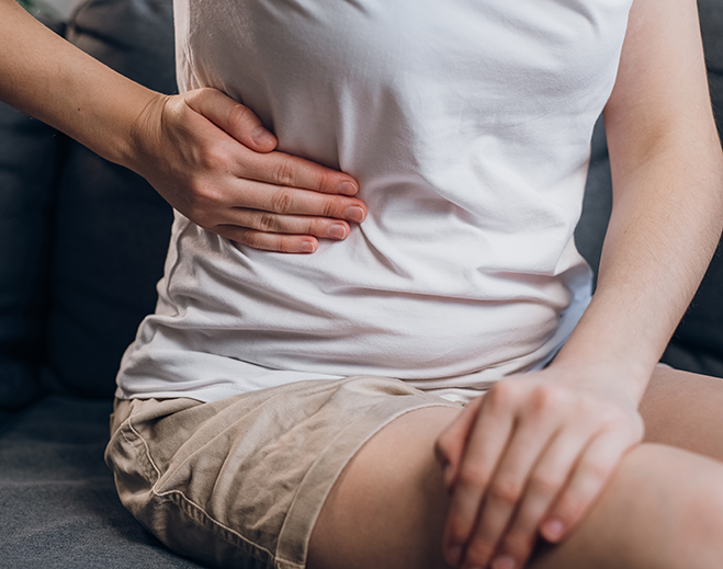 Person holding abdomen in discomfort