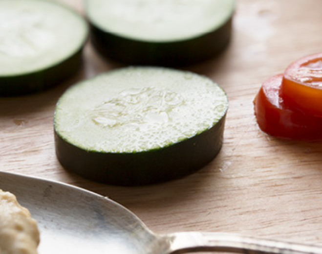 Sliced zucchini and tomato on cutting board
