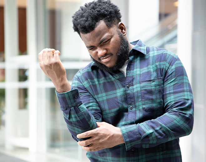 Person holding elbow in discomfort