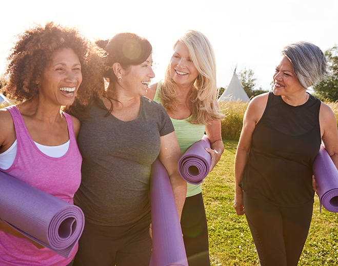 Group walking outdoors with yoga mats