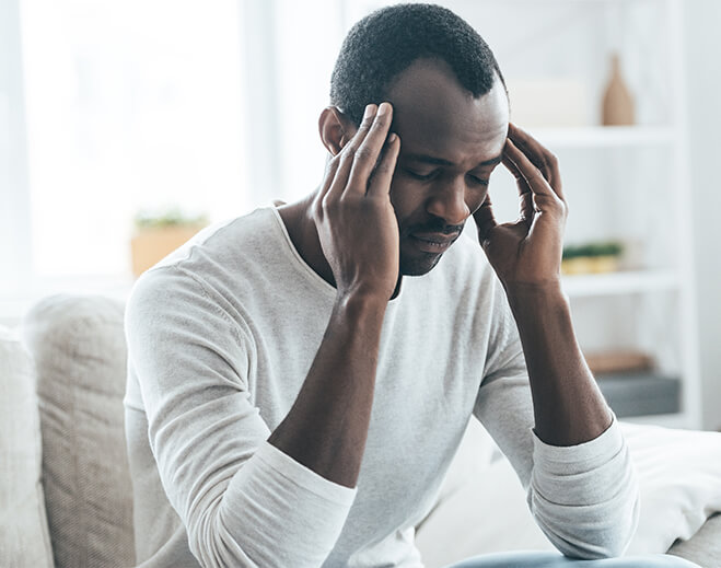 Person holding temples with head discomfort