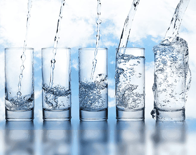 Water being poured into clear glasses