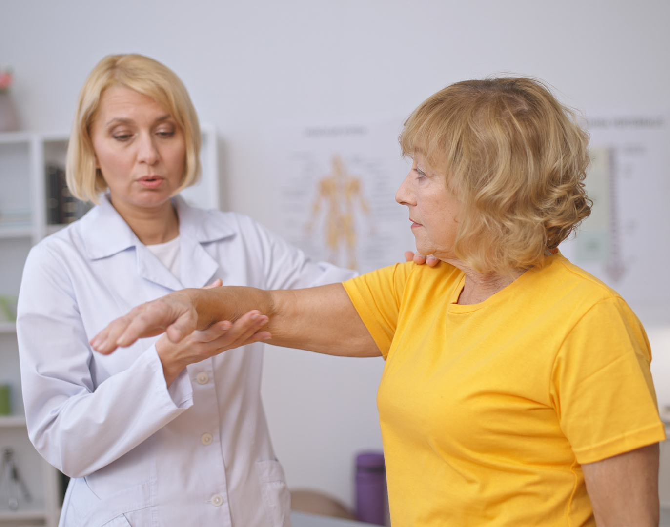 Clinician assessing patient arm mobility