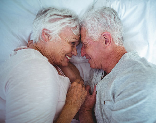 Older couple lying together in bed