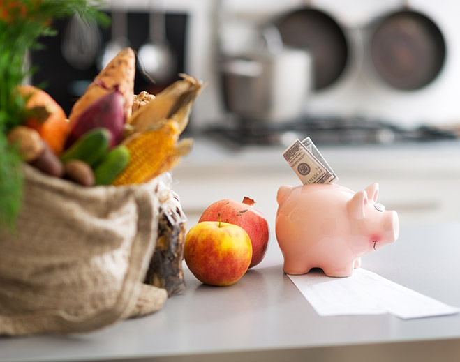 Groceries and piggy bank on kitchen counter