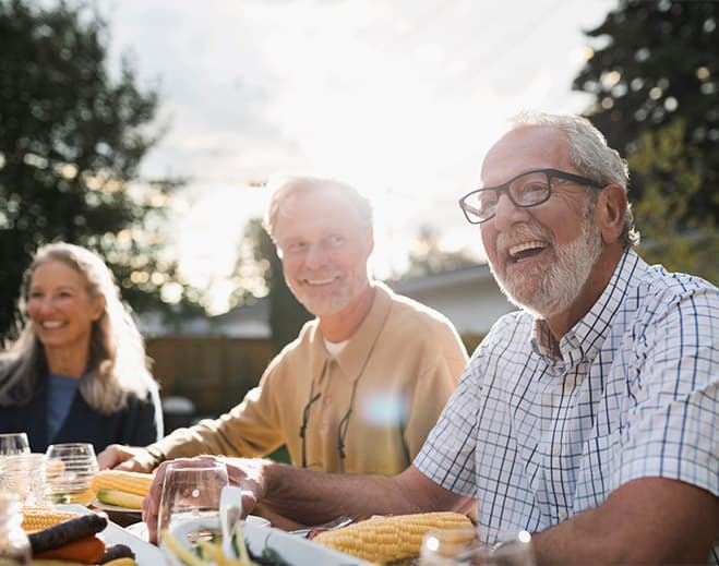 Older adults enjoying meal outdoors together