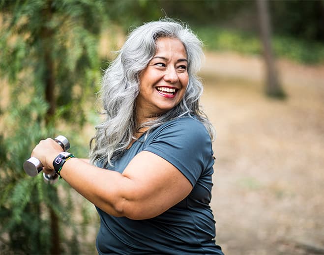 Older adult exercising with dumbbell outdoors