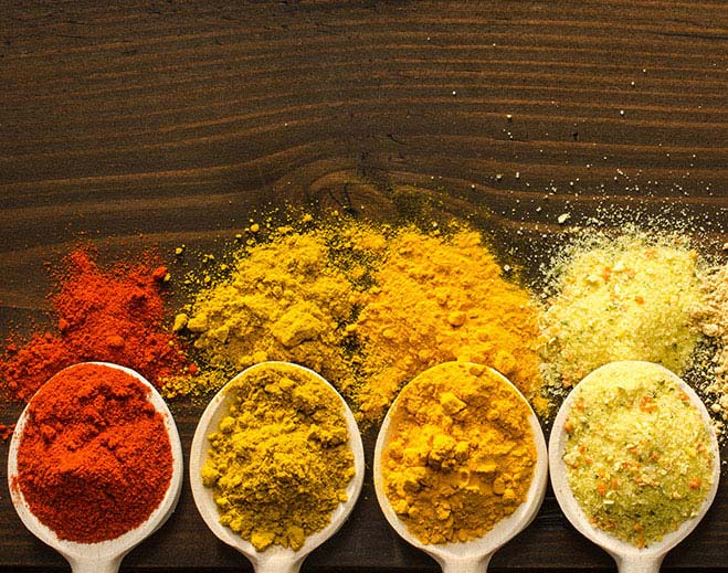 Assorted spices displayed on wooden spoons
