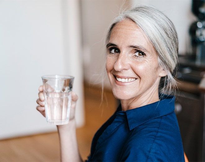 Person holding glass of water smiling