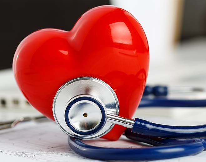 Red heart with stethoscope on table