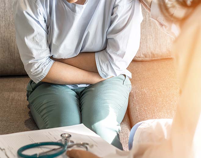 Person holding abdomen during medical visit