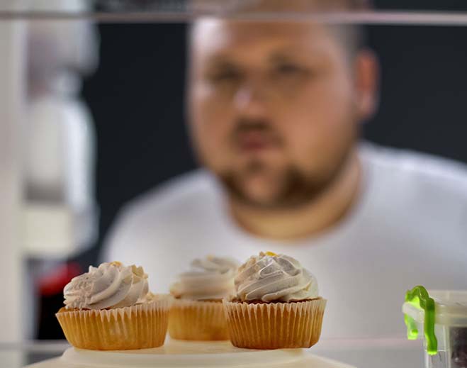 Cupcakes in fridge with person looking