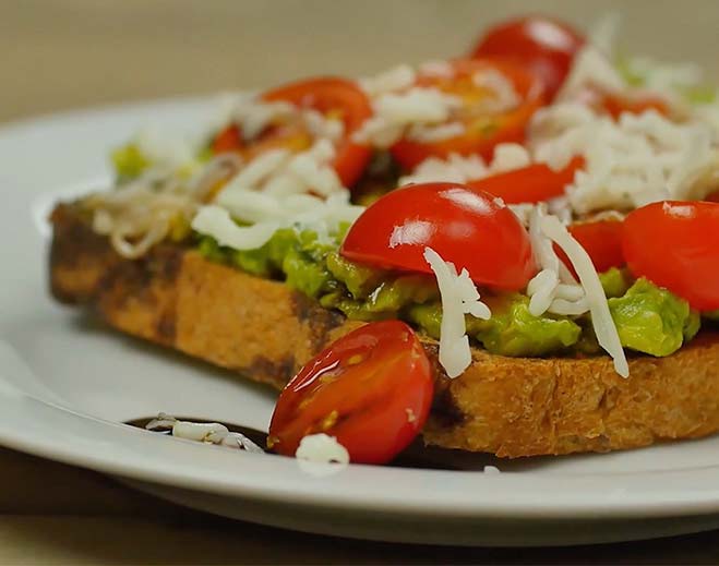 Avocado toast with tomatoes and shredded cheese