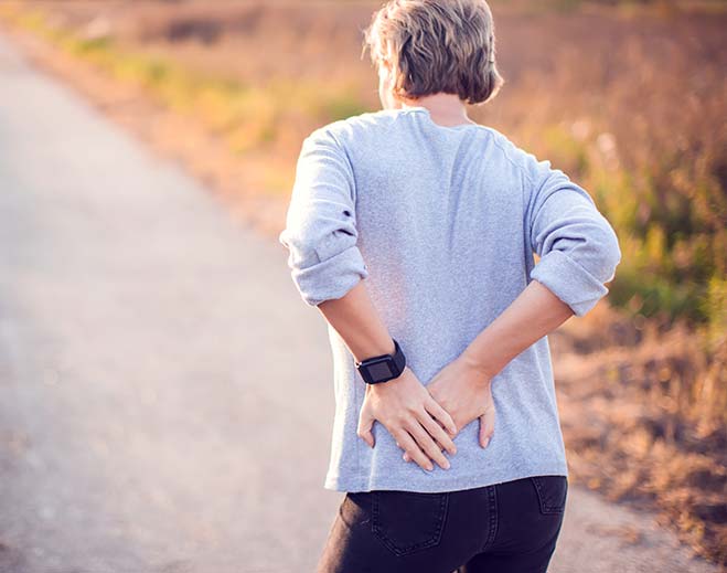 Person holding lower back in pain
