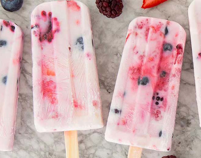 Berry popsicles on marble surface