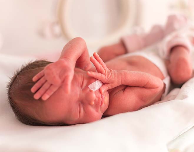Newborn infant resting with medical support