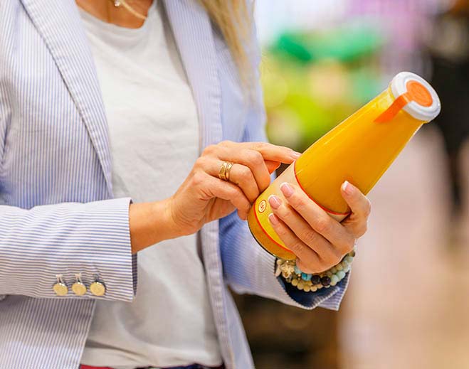 Person reading nutrition label on bottle
