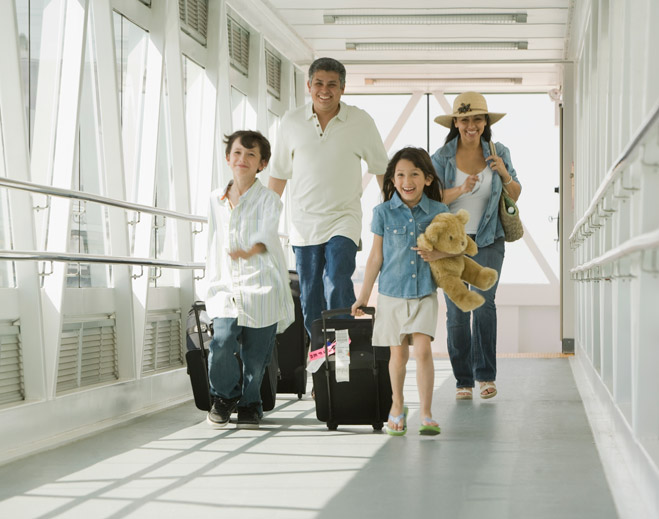 Family walking with luggage in hallway