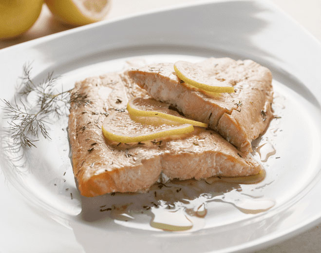 Cooked salmon with lemon slices on plate