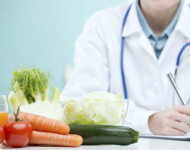 Fresh vegetables beside clinician on desk