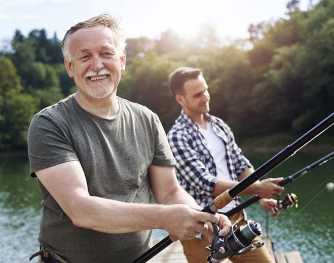 Two people fishing by lakeside