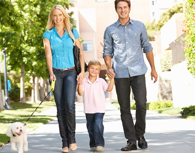People walking outdoors with small dog