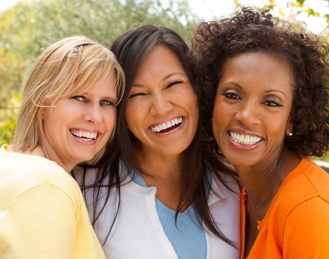 Three people smiling outdoors together