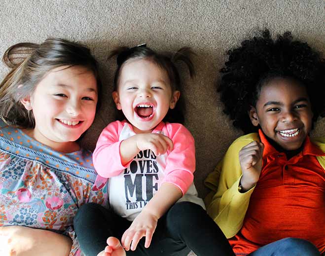 Children lying together and laughing