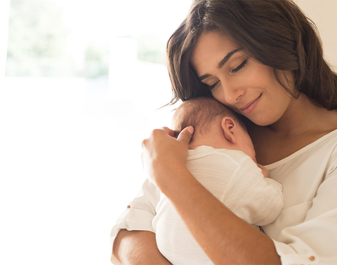 Adult holding newborn close to chest