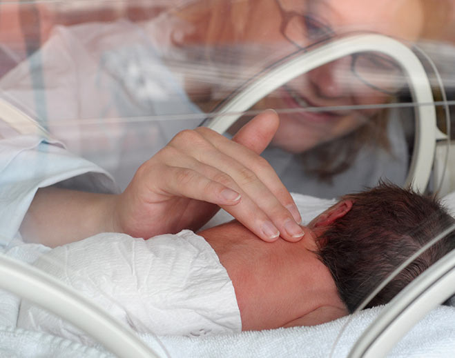 Premature infant in neonatal incubator hospital
