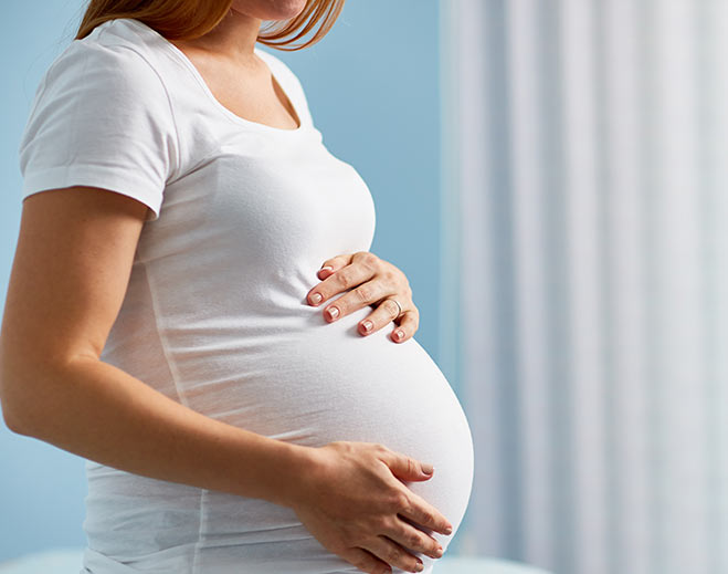 Close-up of pregnant belly with hands