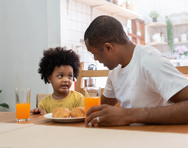 Parent and child having breakfast together