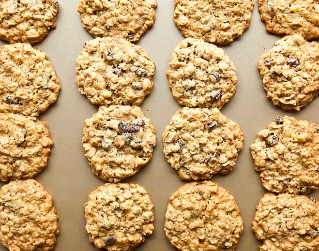 Oatmeal raisin cookies arranged on baking tray