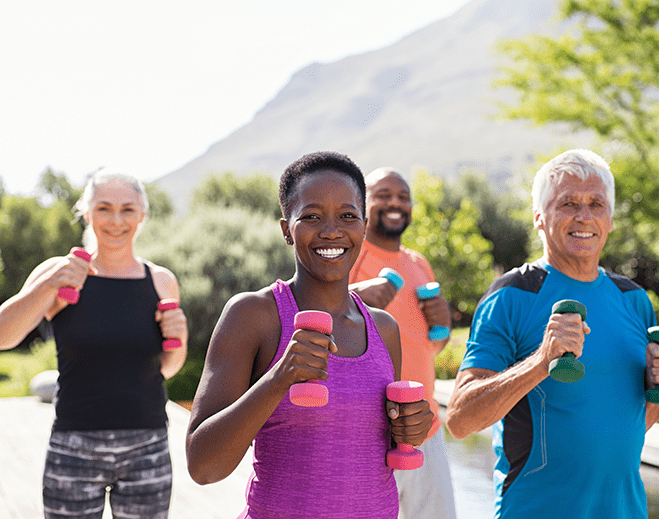 Group doing outdoor exercise with weights