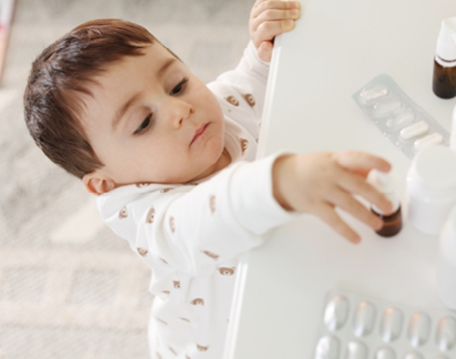 Curious child reaching for medicine bottles