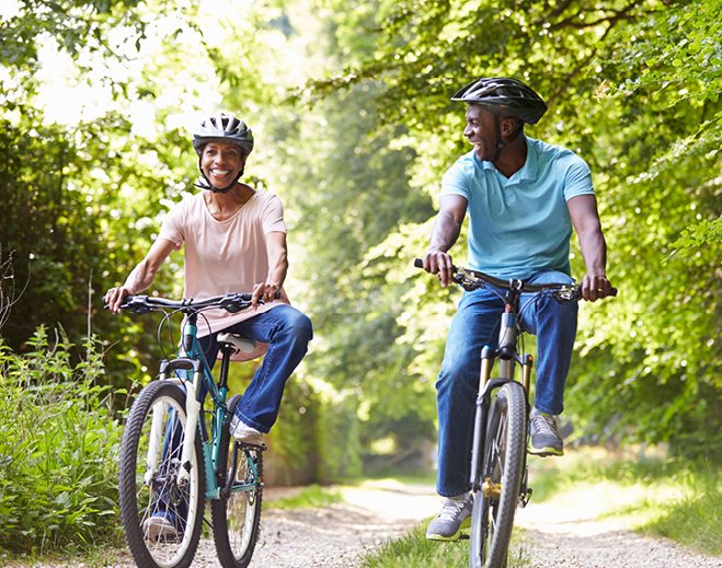 Two people cycling on wooded trail