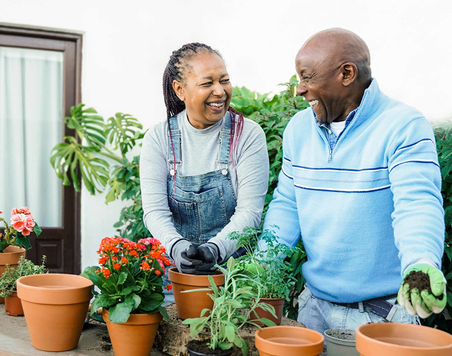 Two people gardening with potted plants