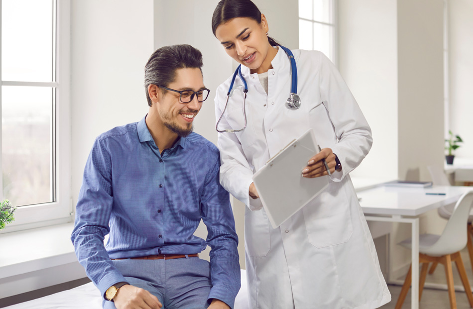 A doctor is talking with a patient in a clinic while showing information on a clipboard
