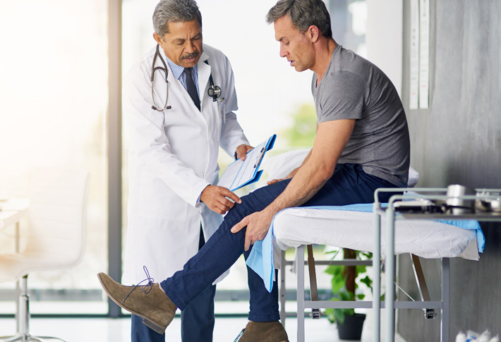 Doctor examining patient’s injured leg