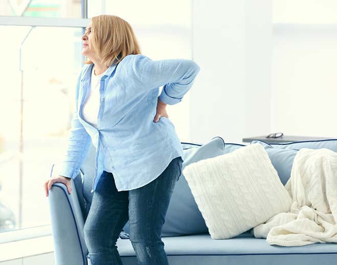 Person holding lower back in pain