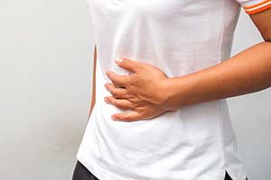Person holding stomach in discomfort