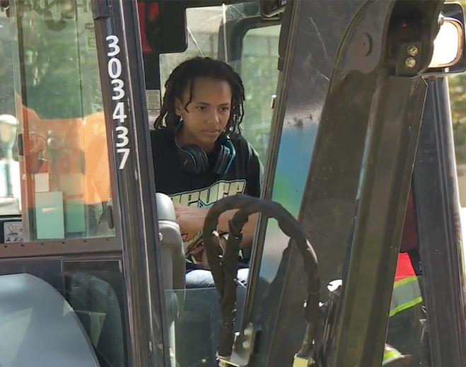 Young boy operating heavy construction equipment
