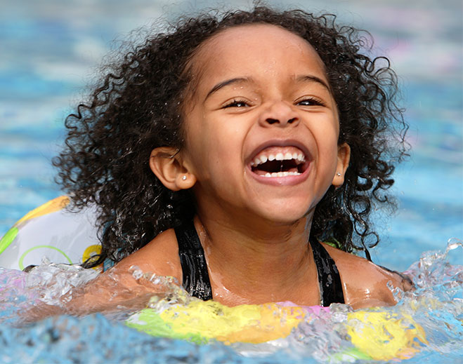 Child swimming with float in pool