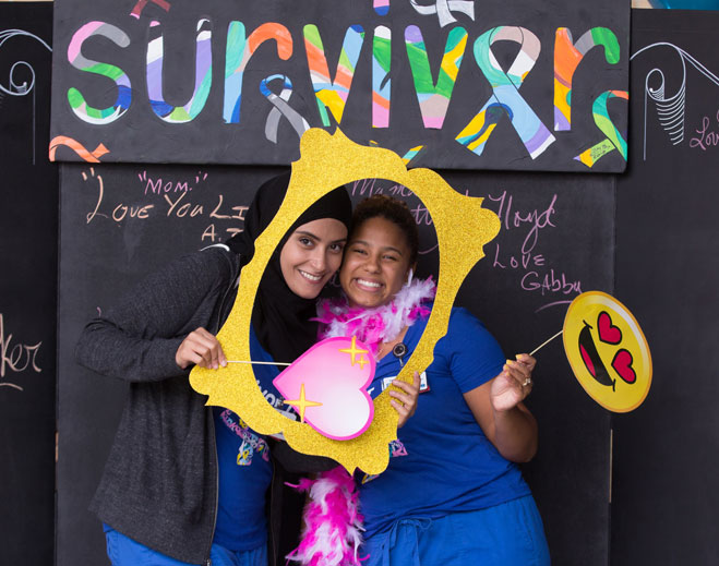 Two people posing with colorful survivor frame