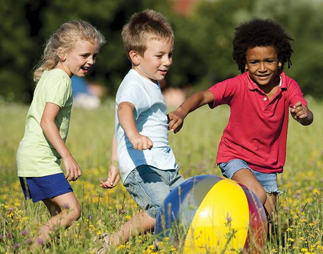 Children playing outdoors with beach ball
